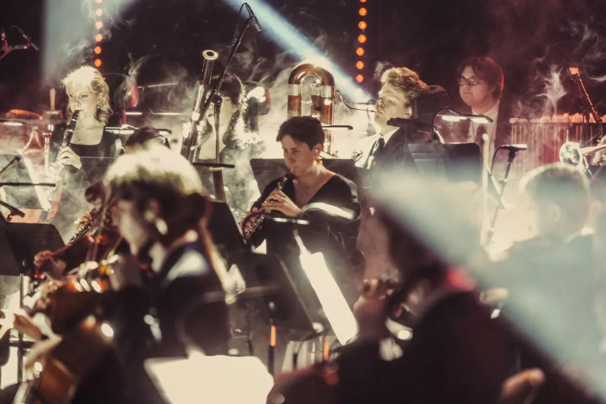 Young musicians of the Bergen Philharmonic Youth Orchestra playing in haze and backlight
