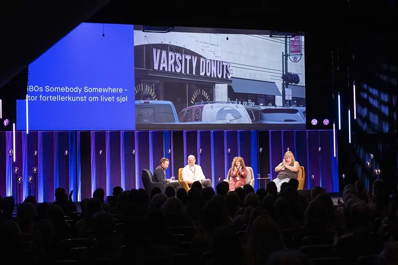 Four-person panel on stage before a large screen at Nordiske Mediedager