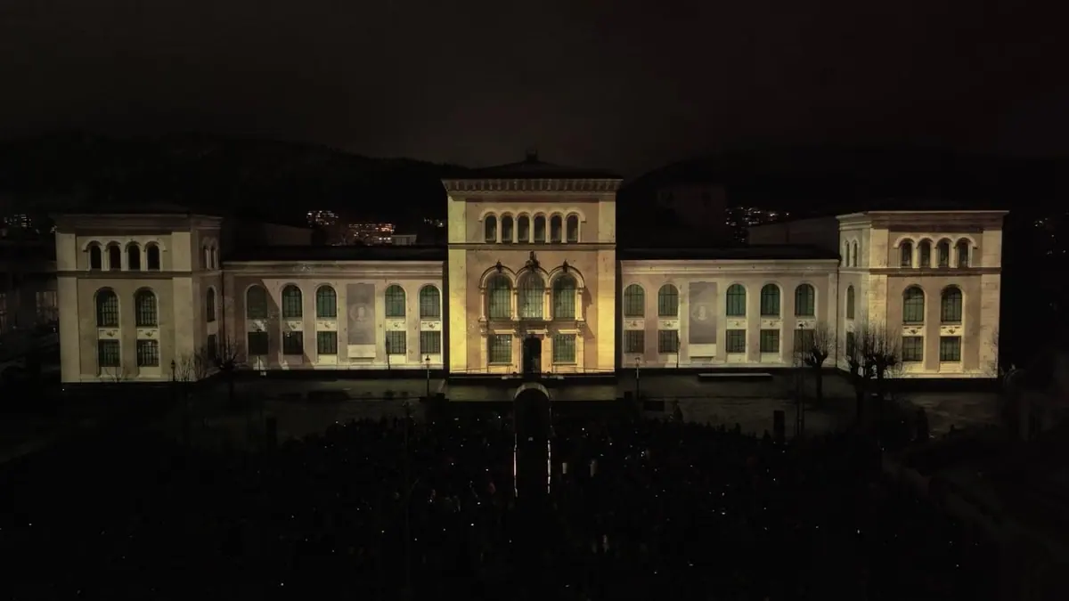 The University Museum of Bergen lit at night with the audience at Muséplassen