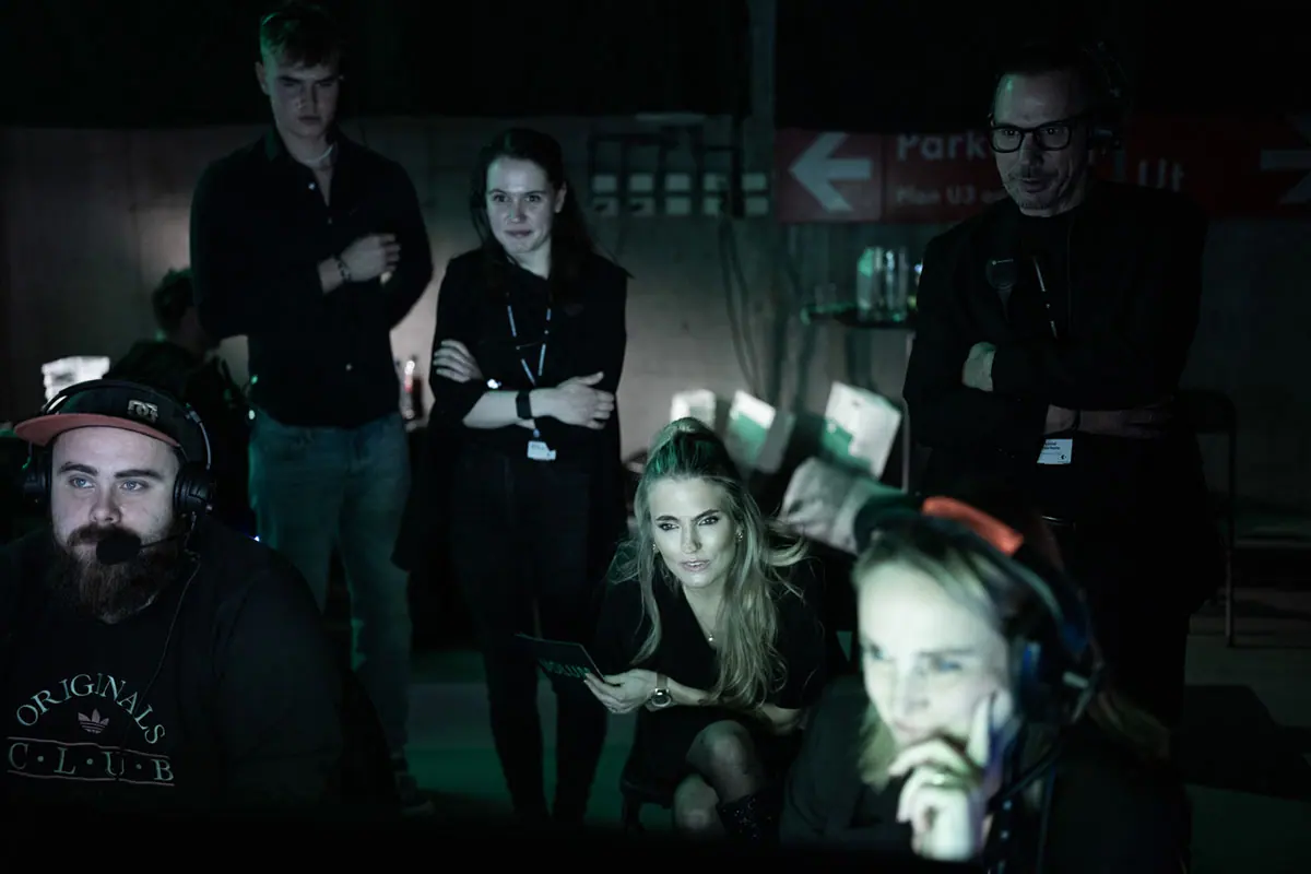 Production team with headsets watching screens in the dark at Volum