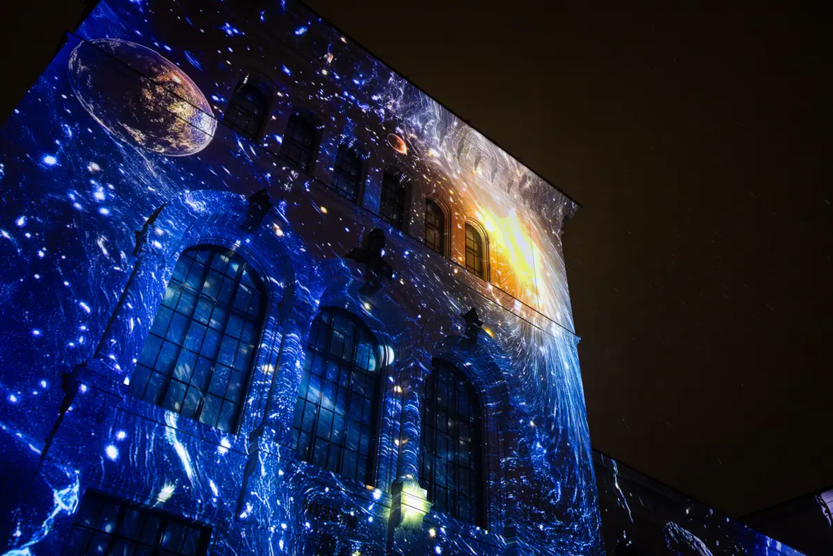 Close-up of the museum facade with projected outer space and planets