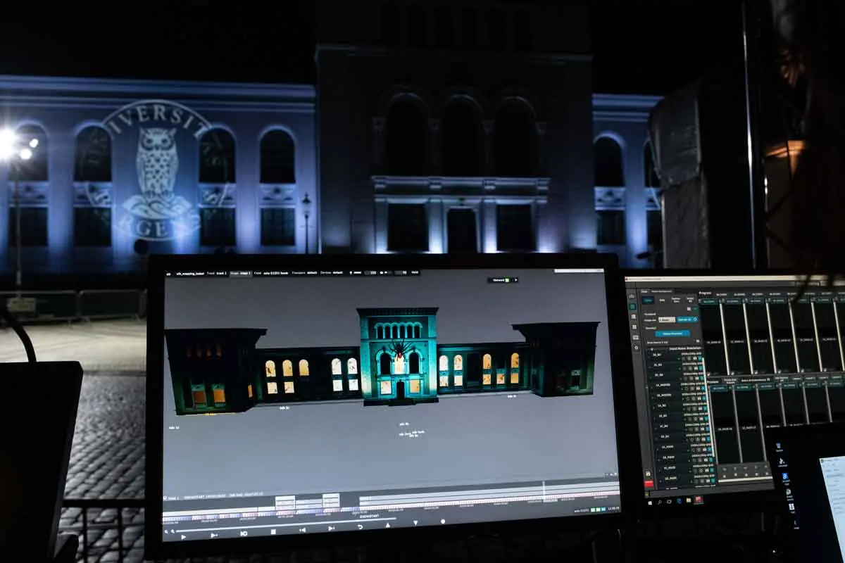 Control screen with a 3D model of the museum in front of the lit facade