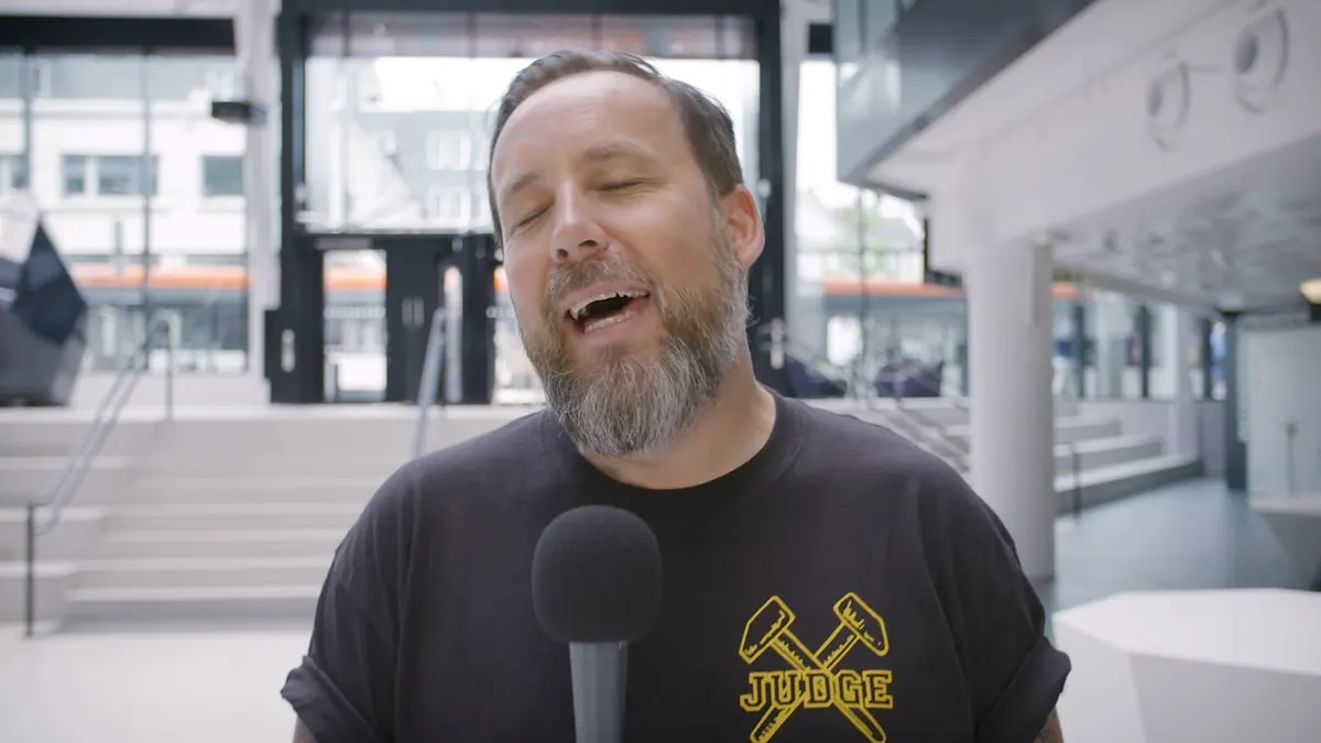 Man singing into a microphone outdoors in a film for UiB's welcome ceremony