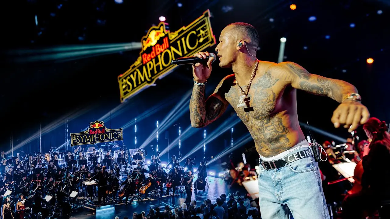 Kamelen rapping in front of the orchestra and Red Bull Symphonic logo in Grieghallen