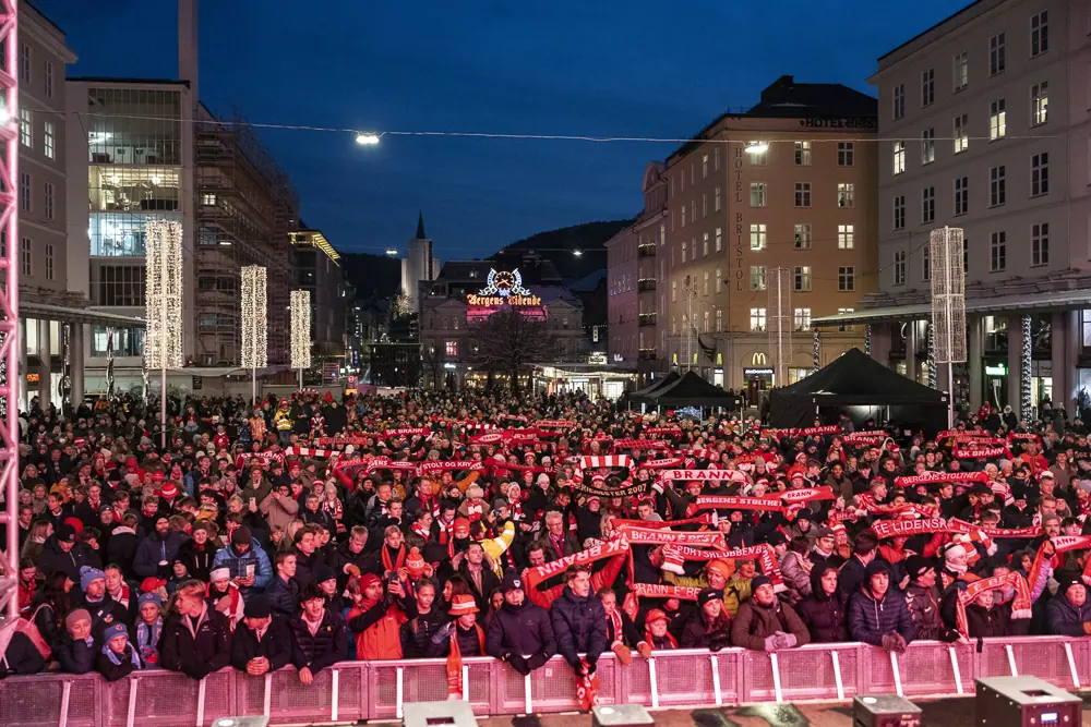 Packed Torgallmenningen with Brann scarves raised in the evening
