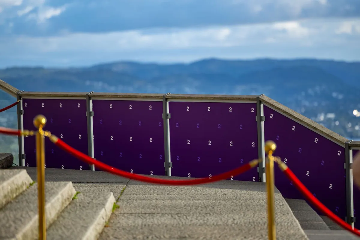 Red carpet with gold posts and a view over Bergen at Fløien