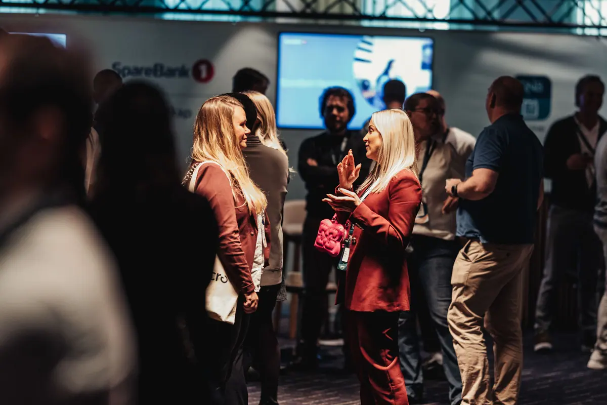 Attendees mingling by exhibitor stands during a break at the Agency Conference