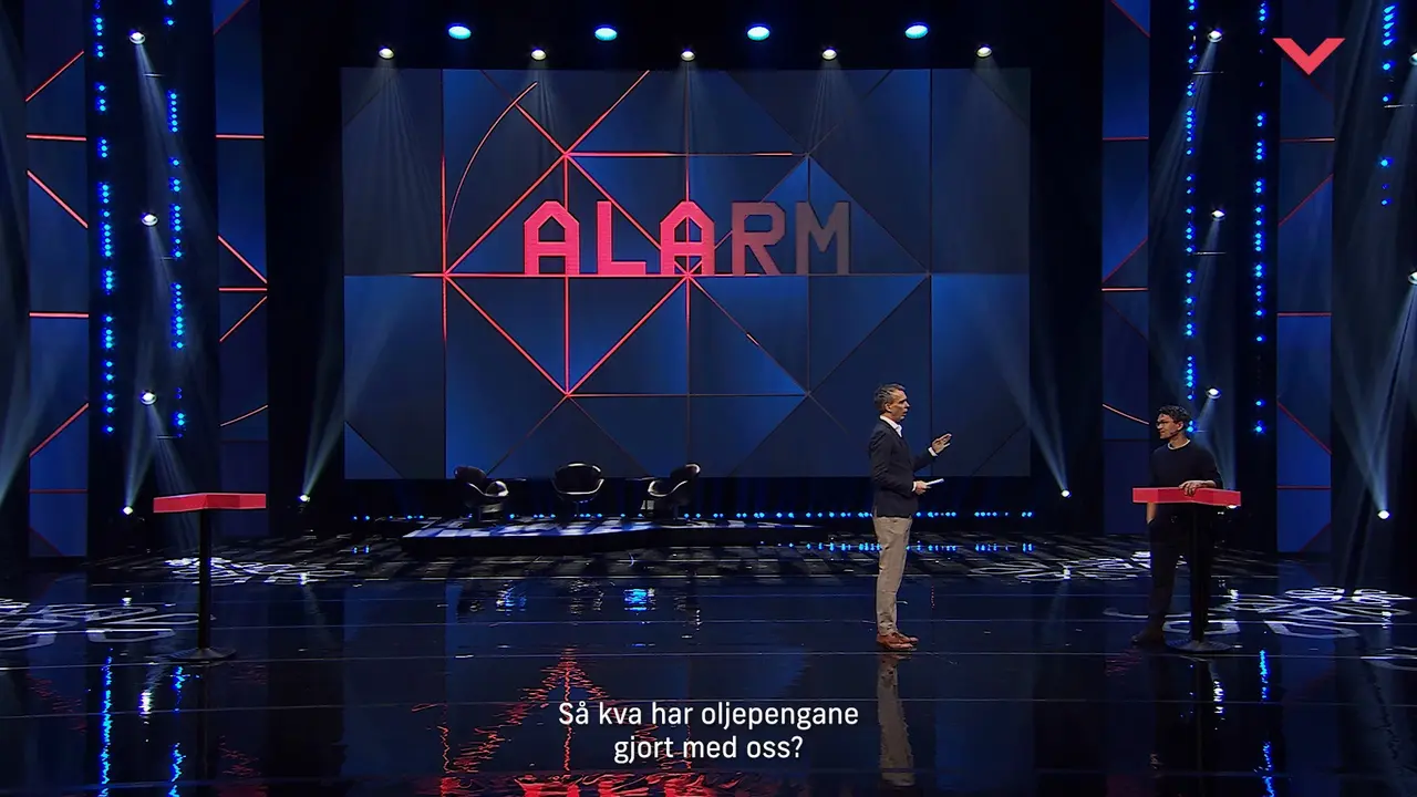 Two hosts on stage before an «ALARM» screen at Vestlandskonferansen