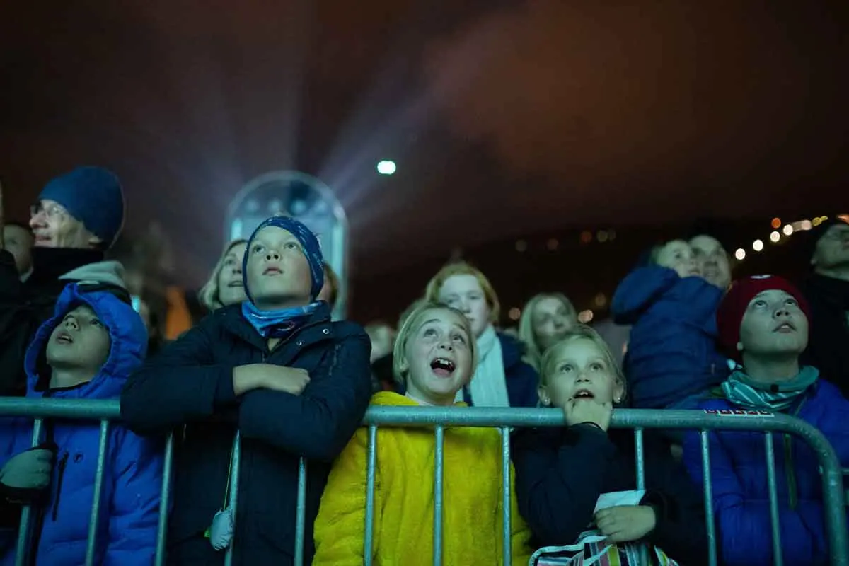 Children at a barrier gazing up in awe at the light show