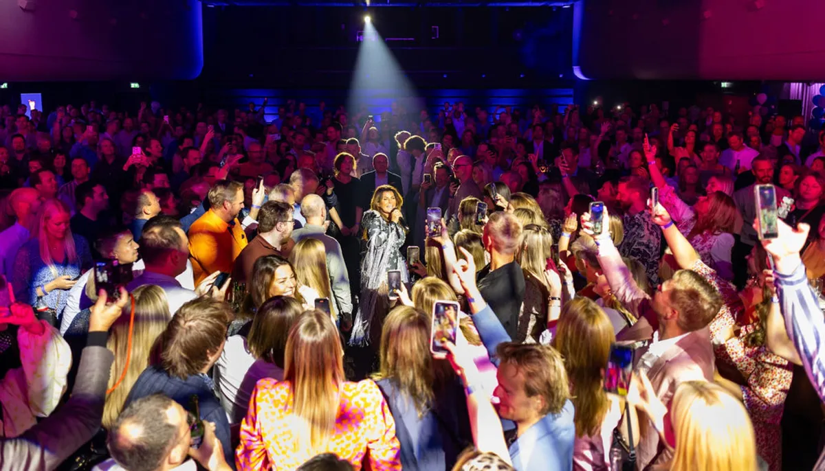 A cheering party crowd in front of the stage