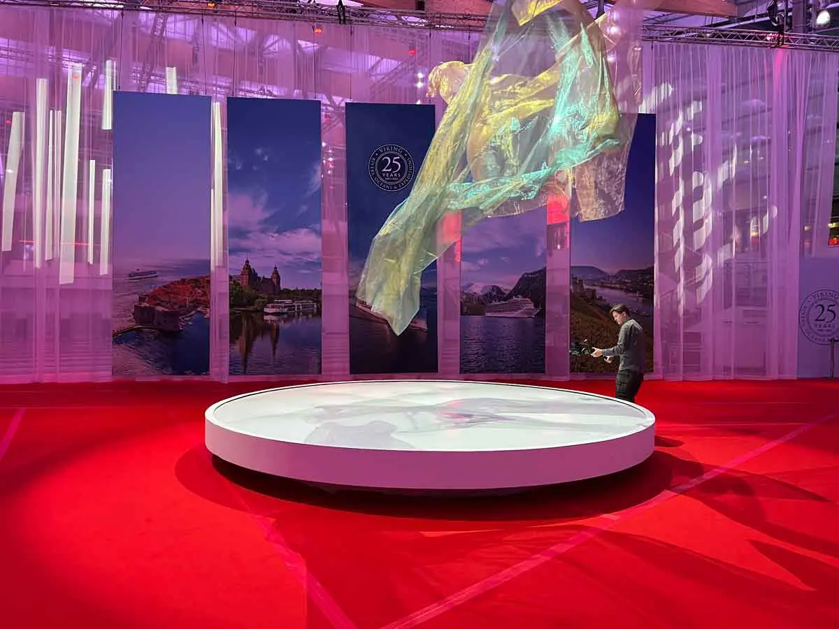 Stage design with red floor, round platform and panels with landscape images