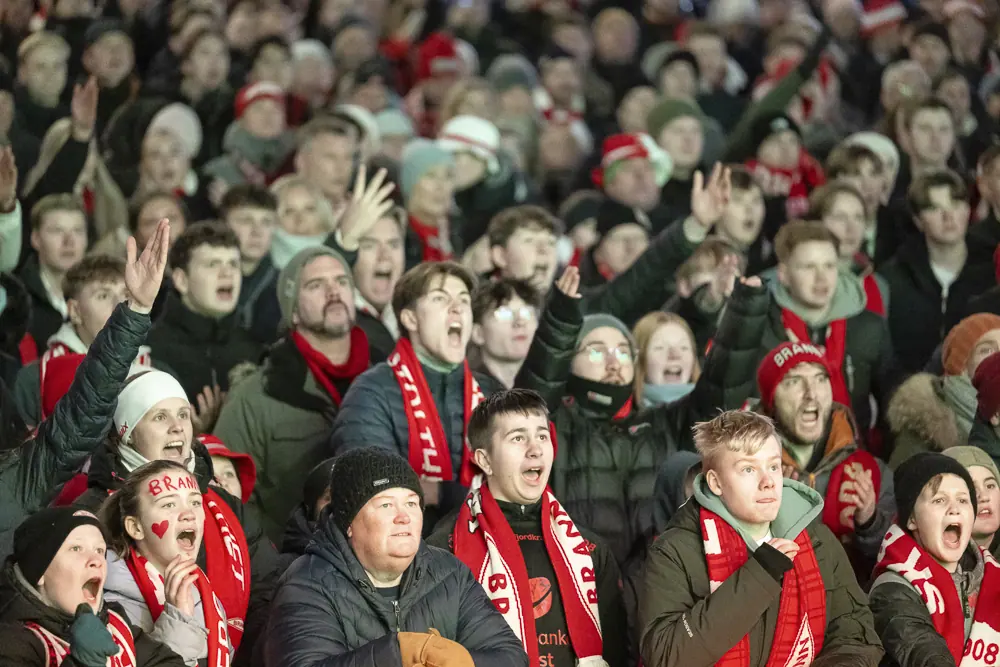 Cheering Brann supporters in red and white on Torgallmenningen