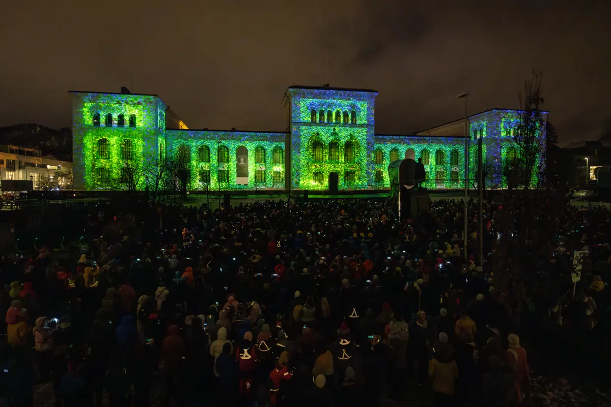 The University Museum bathed in green projections before a large crowd