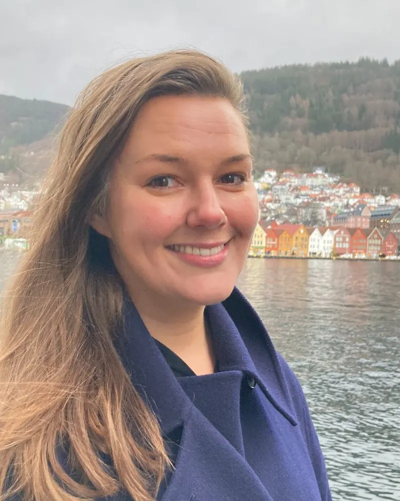 Portrait of Gina Eide, Project coordinator, with Bryggen in the background