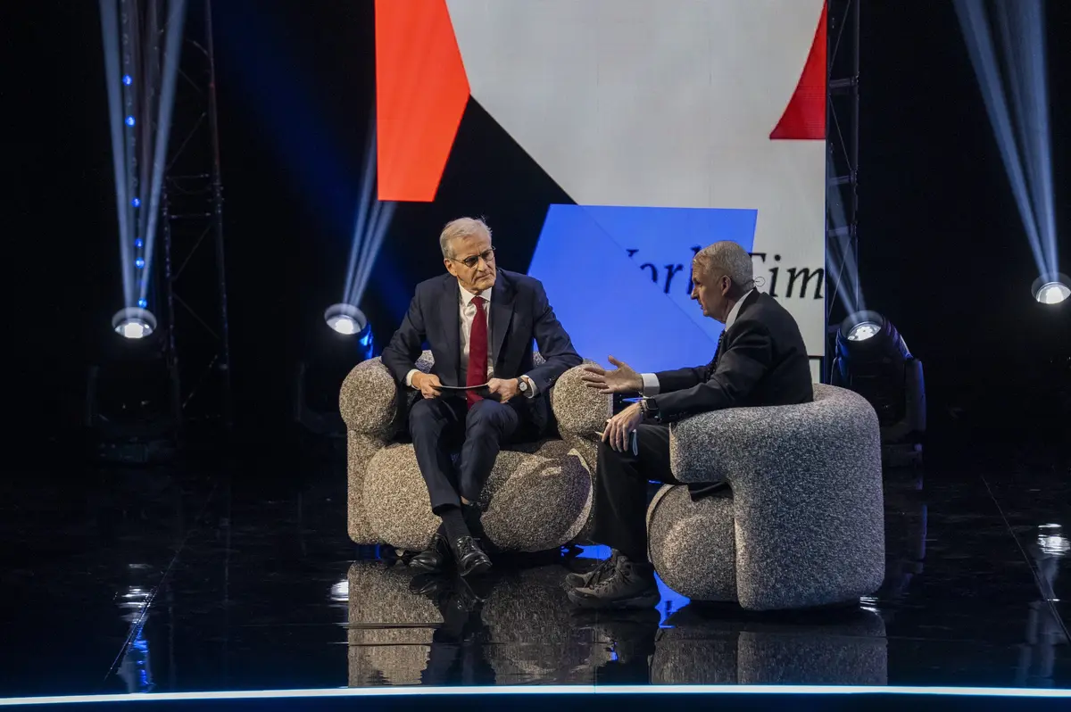 Conversation in armchairs on stage with lighting and graphics behind