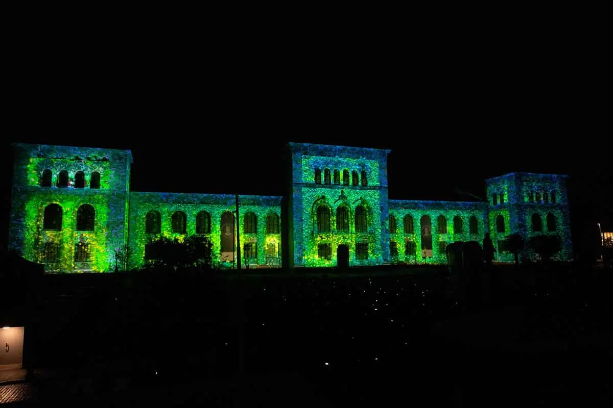 The University Museum in green projections against the night sky