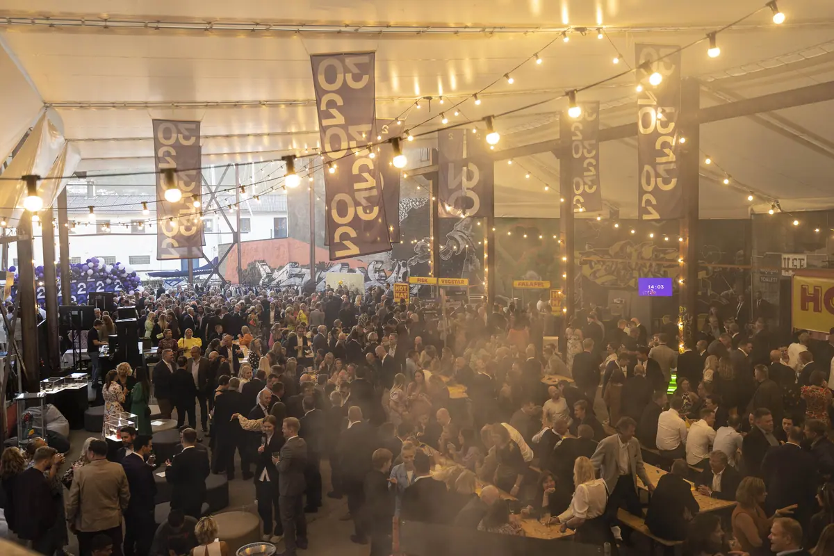 Busy food market under string lights in the courtyard at TV 2's 30th anniversary