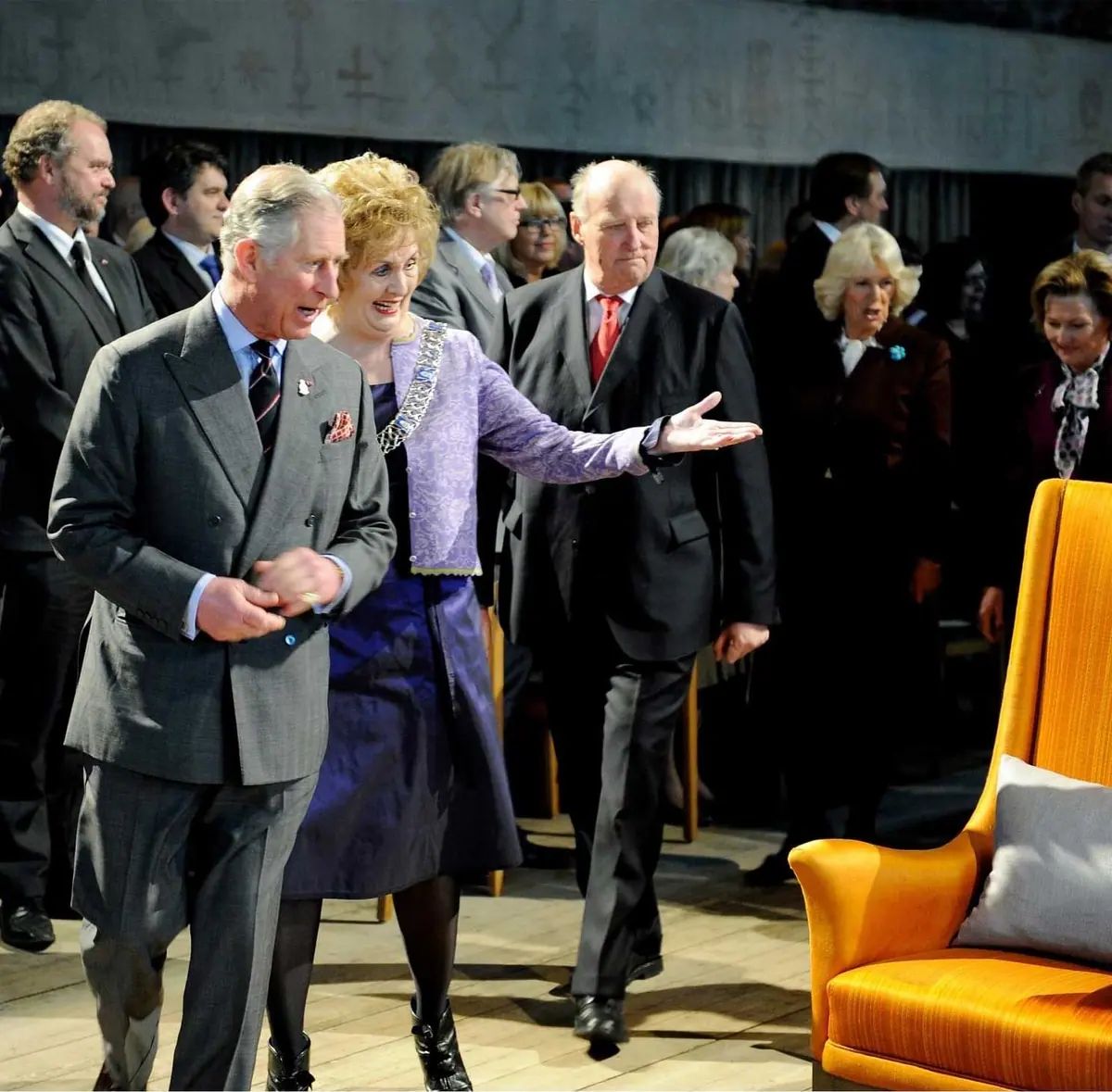 Guests in suits being shown into a hall at an official event