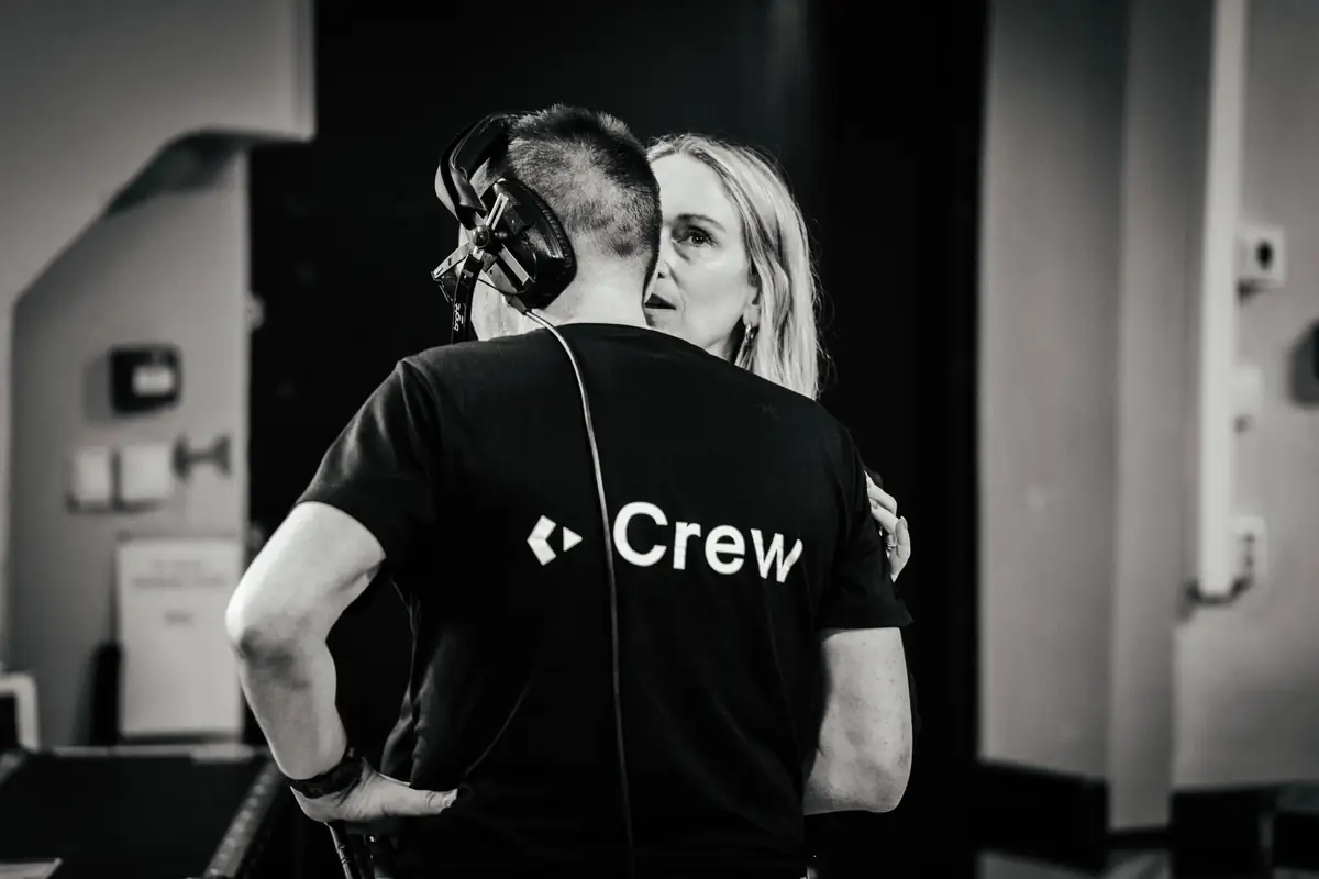 Crew member with headset in conversation backstage, black and white