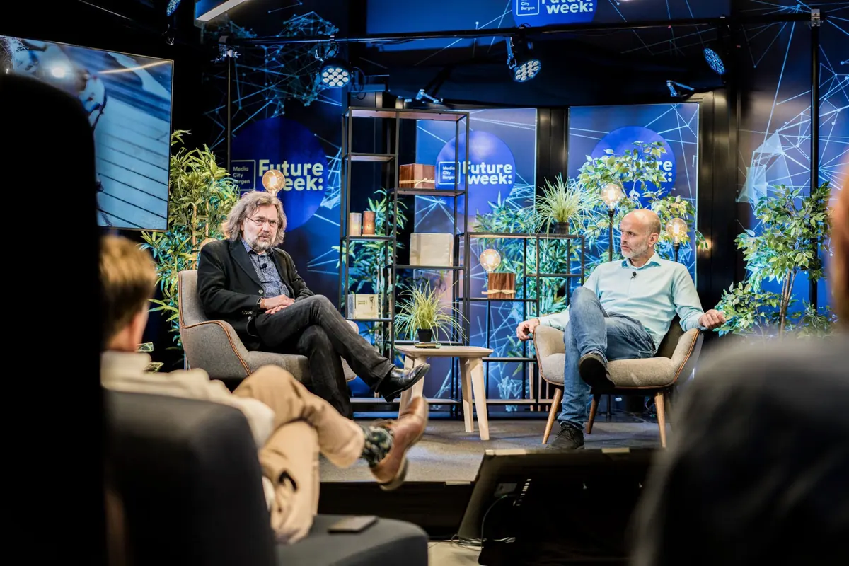 Conversation in armchairs on the Future Week stage with plants and blue screens
