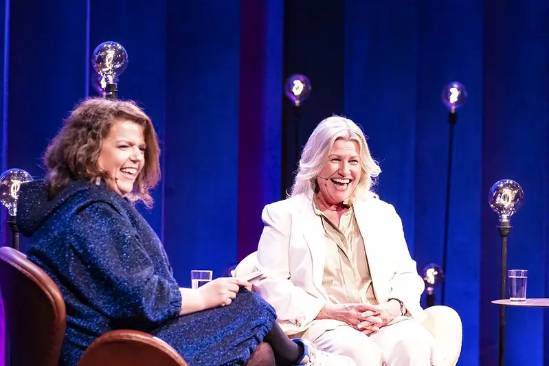 Two women laughing in armchairs on stage at Nordiske Mediedager