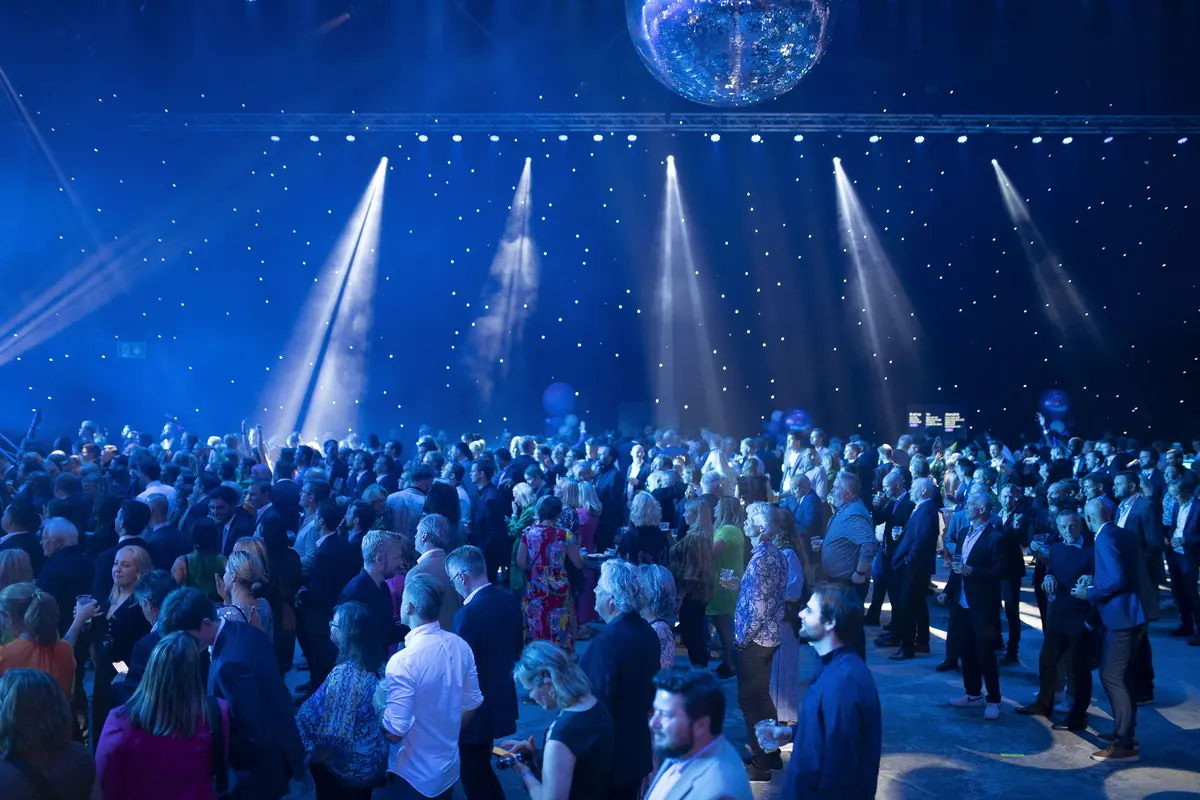 Party crowd under a disco ball and starry ceiling at TV 2's 30th anniversary